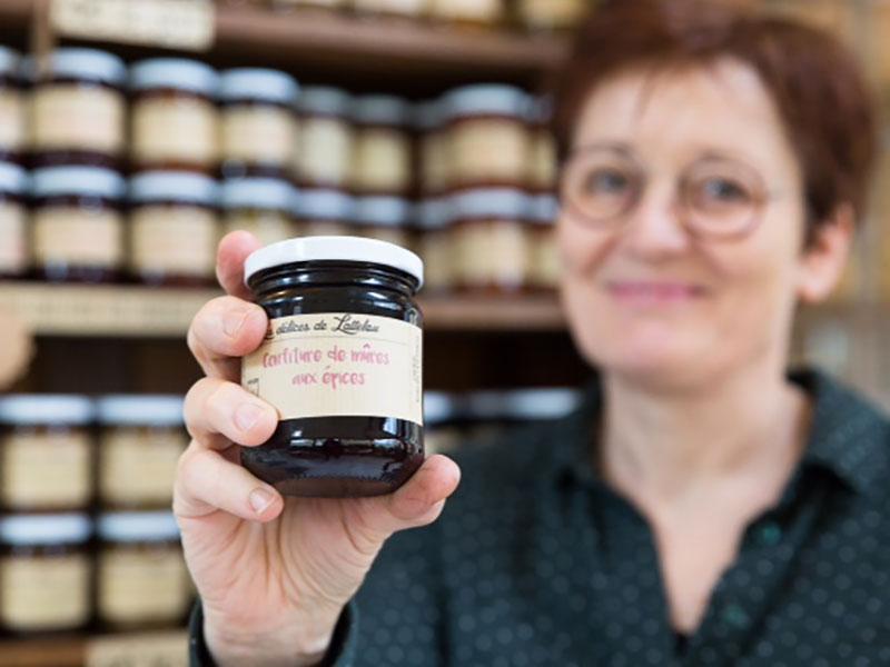 Eliane Briant présentant un de ses pots de confiture - Les Délices de Lattelou - En vente à la maison d'hôtes Ti Ar Yer à Milizac-Guipronvel dans le Nord Finistère (29)